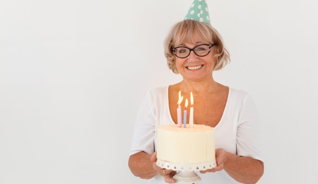 60-jährige Frau mit Geburtstagstorte