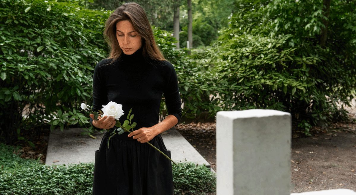 Frau am Grab in angemessener Kleidung