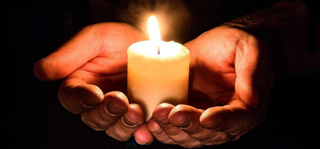 Kerze in betenden Händen