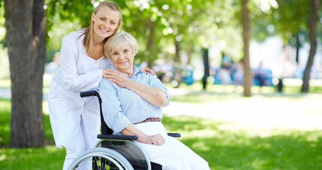 Frau im Rollstuhl mit Betreuerin