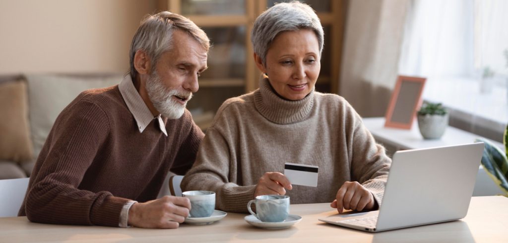 Senioren vor notebook mit Kreditkarte