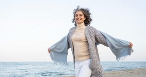 Ältere Frau genießt die Zeit am Strand