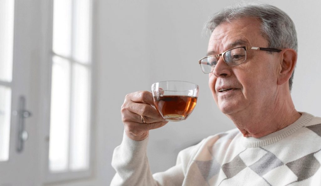 Älterer Mann trinkt Tee